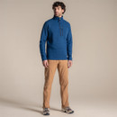 Full-length view of model wearing the blue half-zip fleece with zipped chest pocket, standing in tan trousers.