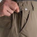 Close-up of the zipped security pocket on the pebble-coloured NosiLife cargo shorts, showing the zip pull and branding.