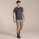 Full-length view of the model wearing the pebble shorts with a dark technical T-shirt and hiking boots.