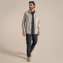 Full-length view of the model wearing the parchment adventure shirt over a black T-shirt with dark walking trousers and boots.