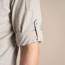 Close-up of the parchment shirt sleeve rolled up with the buttoned tab.