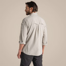 Back view of the model wearing the parchment long-sleeved adventure shirt with sleeves rolled up.