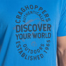 Close-up of the chest print showing “CRAGHOPPERS” and “DISCOVER YOUR WORLD” circular logo design on the blue T-shirt.