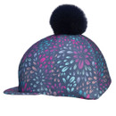 Firework print riding hat cover in navy with black faux fur pom pom and stitched panels, three-quarter view.