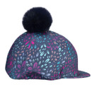 Side profile of navy riding hat cover with multicolour firework print, structured peak and black faux fur pom pom.