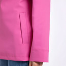 Close-up of a bright pink waterproof jacket showing the vertical welt pocket and cuff seam.
