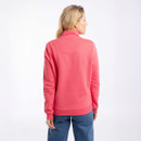 Back view of model wearing the coral-pink half-zip sweatshirt with a funnel neck and ribbed hem.