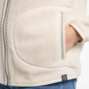 Close-up of the ecru teddy fleece showing the front patch pocket, hand-warmer pocket opening and small woven logo tab at the hem.