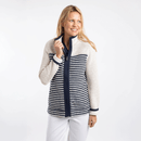 Woman wearing an ecru and navy striped zip-up fleece jacket with textured knit, high collar, and long sleeves, paired with white trousers.