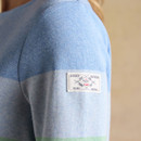 Close-up of the Joules sleeve badge stitched onto the pastel blue section of the jumper.