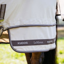 Close-up of a horse wearing a light-coloured LeMieux Kudos rug with two brown straps and silver clips. The design is sleek and sophisticated.