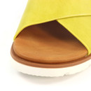 Close-up of the tan cushioned footbed and bright yellow strap on the mule sandal, showing texture and edge details.