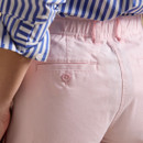 Rear close-up of pale pink chinos showing back welt pocket with matching button and elasticated waistband.