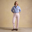 Full-length outfit shot featuring pale pink chinos with a blue-and-white striped shirt and cuffed hems.