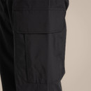 Close-up of black cargo trouser thigh pocket with flap closure and stitched panel detailing.