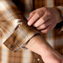 Close-up of sleeve cuff on Carhartt plaid shirt with snap-fastening adjustment.