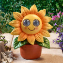Sunflower-shaped garden ornament light in a terracotta pot with LED eyes, displayed unlit in a garden setting during daylight.