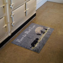 Kitchen featuring a textured doormat with sheep design and "Nice to Meet Ewe" text, next to a cream-coloured AGA stove, on beige tile flooring.