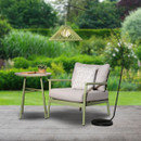 Arched outdoor floor lamp with a sage green slatted shade, styled beside a patio chair and side table in a garden setting.