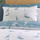 Close-up of a pillowcase featuring a blue sailboat and seabird print on a white background.