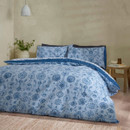 Reversible duvet cover showing the blue patterned side with floral and geometric motifs, styled on a neatly made bed.