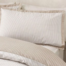 Close-up of a pinstripe pillowcase with beige edging detail, styled on neutral bedding.