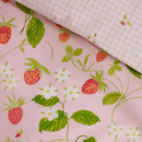 Detailed close-up of the duvet cover fabric showing strawberries, green leaves and white flowers on a pink background.