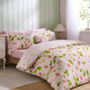 Pink strawberry print duvet cover set styled on a bed in a light, pastel bedroom with green panelled walls.
