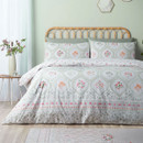 Floral patterned duvet cover set with sage green accents and rattan headboard styling