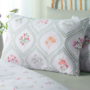 Close-up of pillowcase with decorative floral motifs framed by sage green geometric borders