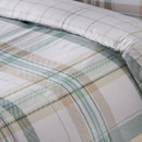 Detailed close-up of a green and neutral tartan duvet cover highlighting the intersecting check design and soft fabric finish.
