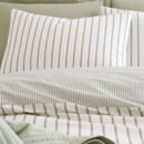 Close-up of a striped pillowcase showing vertical sage green stripes on a white background.
