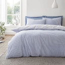 Reverse side of a blue and white striped duvet cover showing fine pinstripes on a neatly made bed.