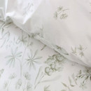 Detailed view of white duvet fabric with subtle green floral illustrations and stitched edge.