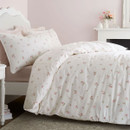 White and pink floral duvet cover styled in a romantic bedroom with pastel décor and wooden flooring.