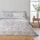 Leaf print duvet cover set in soft neutral and sage green tones, styled on a double bed in a bright, modern bedroom.
