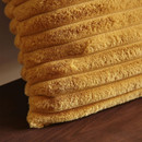 Close-up of mustard yellow ribbed faux fur cushion showing soft plush texture and raised channels
