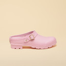 Side profile of a single pastel pink clog with adjustable gold buckle strap and chunky treaded sole.