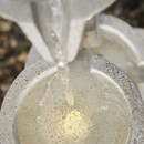 Top view of water bubbling into the lower basin with a soft warm LED light underneath.