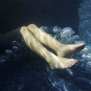 Close-up of legs submerged in bubbling water inside a Lay-Z-Spa inflatable hot tub.