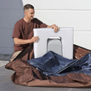 A man placing a rigid insulation panel into a Lay-Z-Spa inflatable hot tub during setup on a patio.
