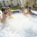 Group of friends enjoying bubbling water inside a Lay-Z-Spa Toronto hot tub outdoors.
