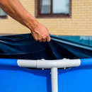 Close-up of hand pulling Intex pool debris cover over frame pool edge