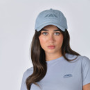 Model wearing light blue WeatherBeeta baseball cap, front close-up view