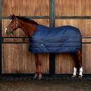 Horse wearing navy quilted stable rug in stable