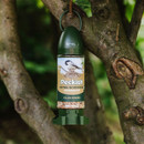 A green bird feeder labelled "Peckish" with seed mix inside, hanging from a tree branch in a garden setting, suggesting a peaceful, natural environment.