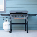 Front view of Blackstone gas griddle with hood closed and propane tank attached
