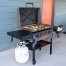 Blackstone gas griddle with hood cooking steaks and vegetables on outdoor patio