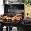 Traeger Woodridge pellet grill cooking outdoors with BBQ sauce on side shelf