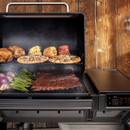 Front view of Traeger Woodridge grill loaded with ribs, vegetables and pizzas